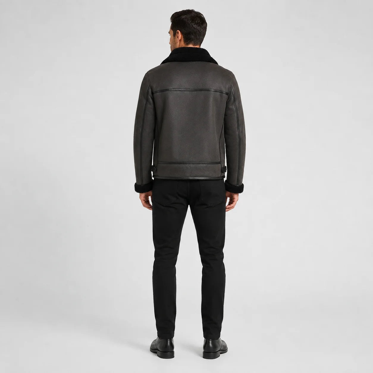Rear studio view of charcoal aviator jacket showing black collar, panel seams and adjustable side waist tabs