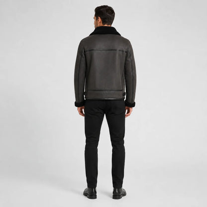 Rear studio view of charcoal aviator jacket showing black collar, panel seams and adjustable side waist tabs