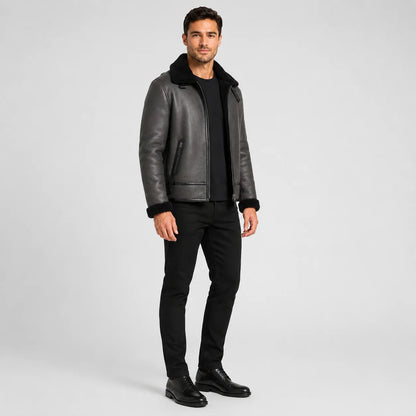 Three-quarter studio view of grey flight jacket with black plush trim, zip pockets and structured short silhouette