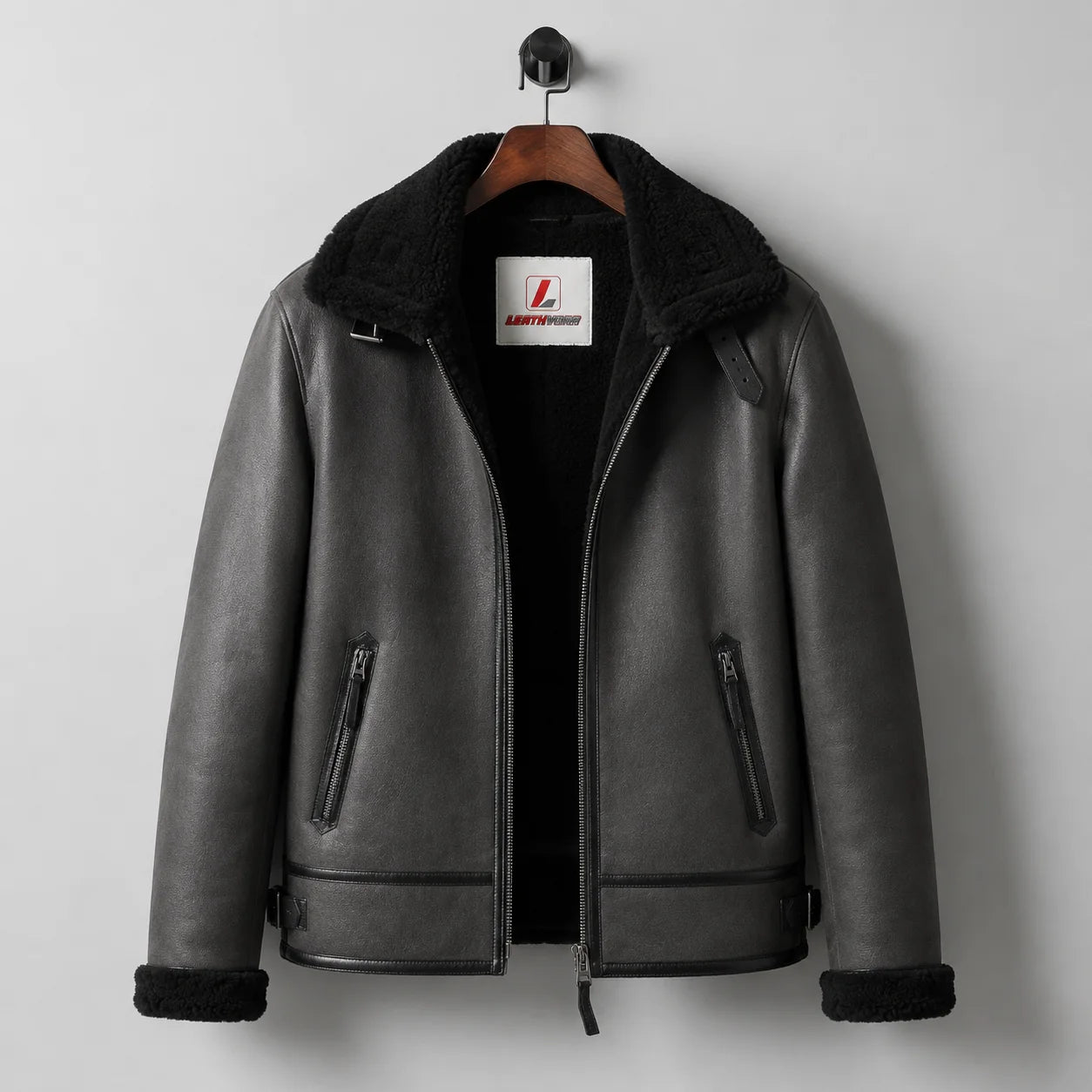 Hanging front view of charcoal aviator jacket with black plush lining, collar buckle and two zipped hand pockets
