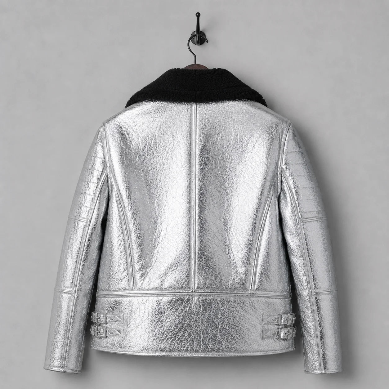 Rear hanging view of shiny silver shearling leather jacket showing centre seam, shaped panels and side buckle straps