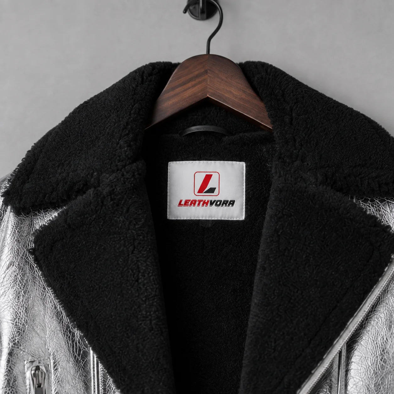Close-up of thick black shearling collar and interior on silver leather jacket with stitched Leathvora neck label