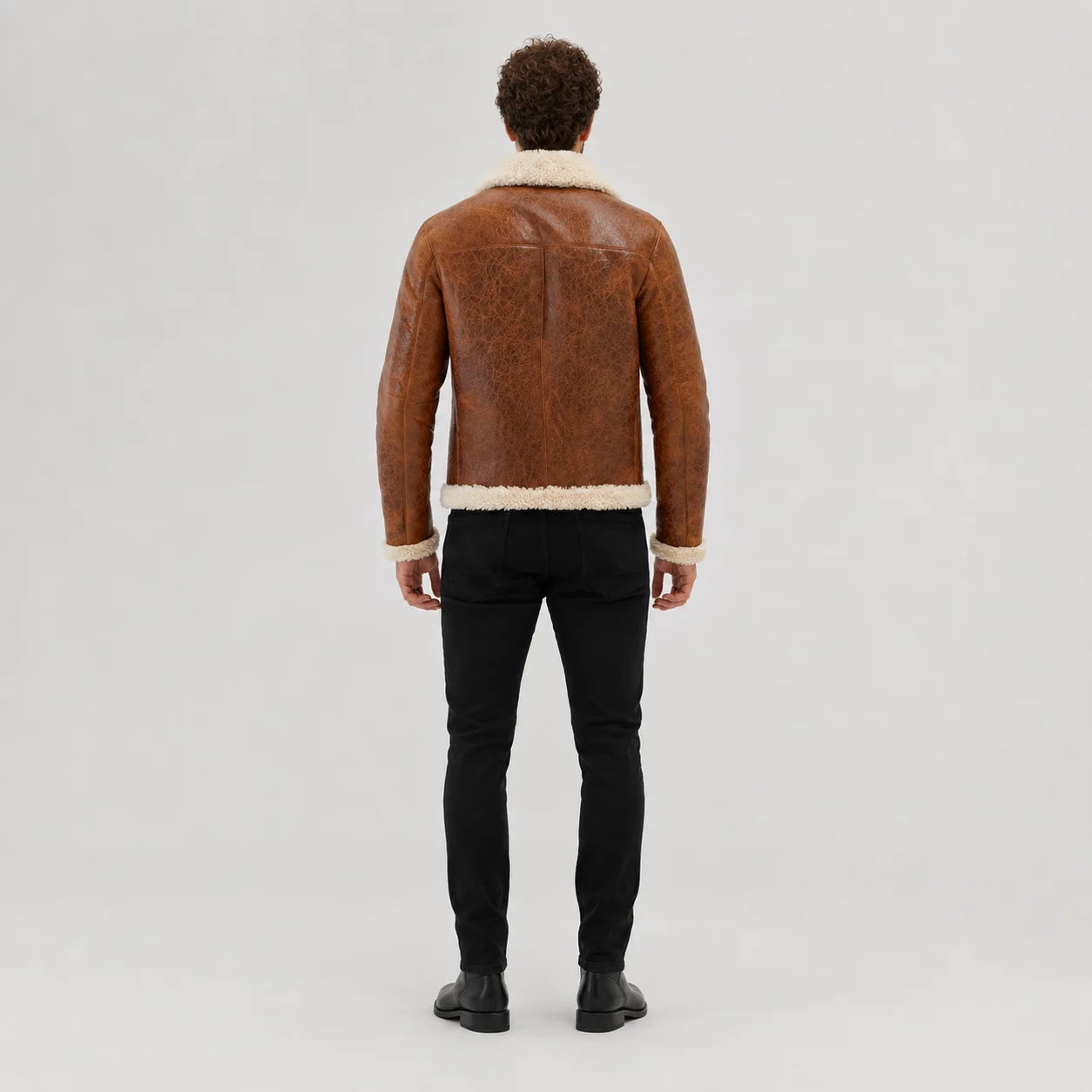 Rear studio view of tan flight jacket showing cream collar and hem trim with clean centre and shoulder seams