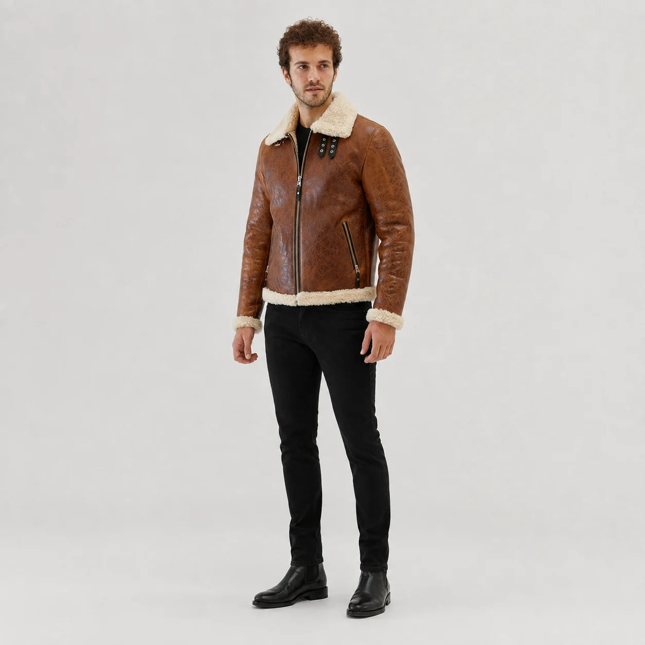 Three-quarter studio view of cognac aviator jacket with off-white collar, zip pockets and textured vintage finish