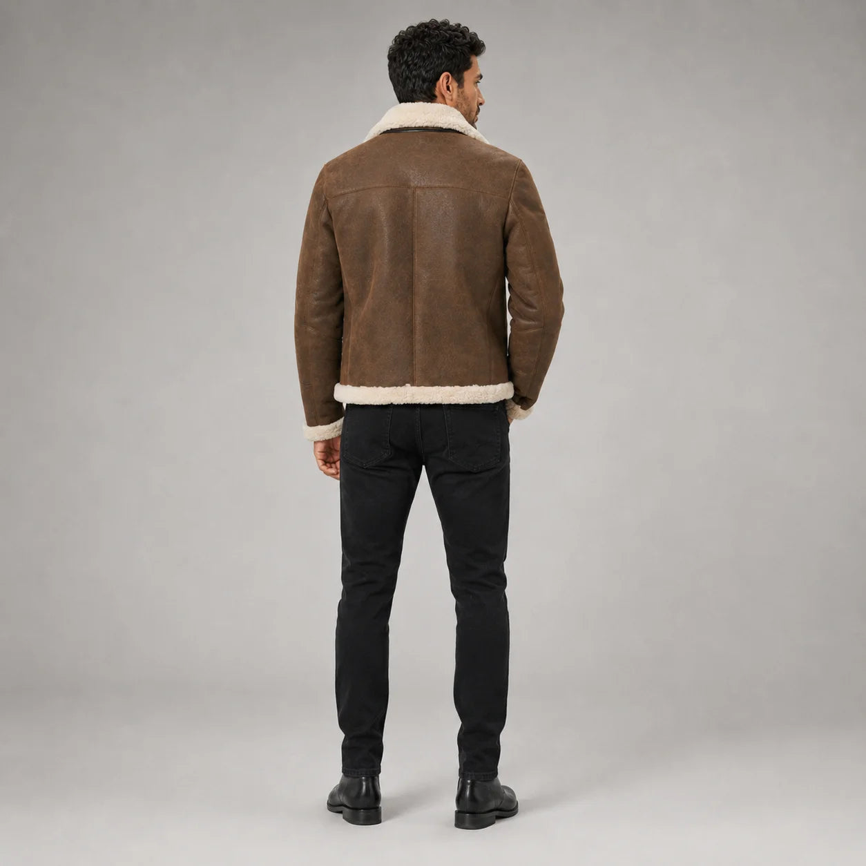 Rear studio view showing brown aviator jacket shoulder yoke, centre seam and cream plush collar and hem trim