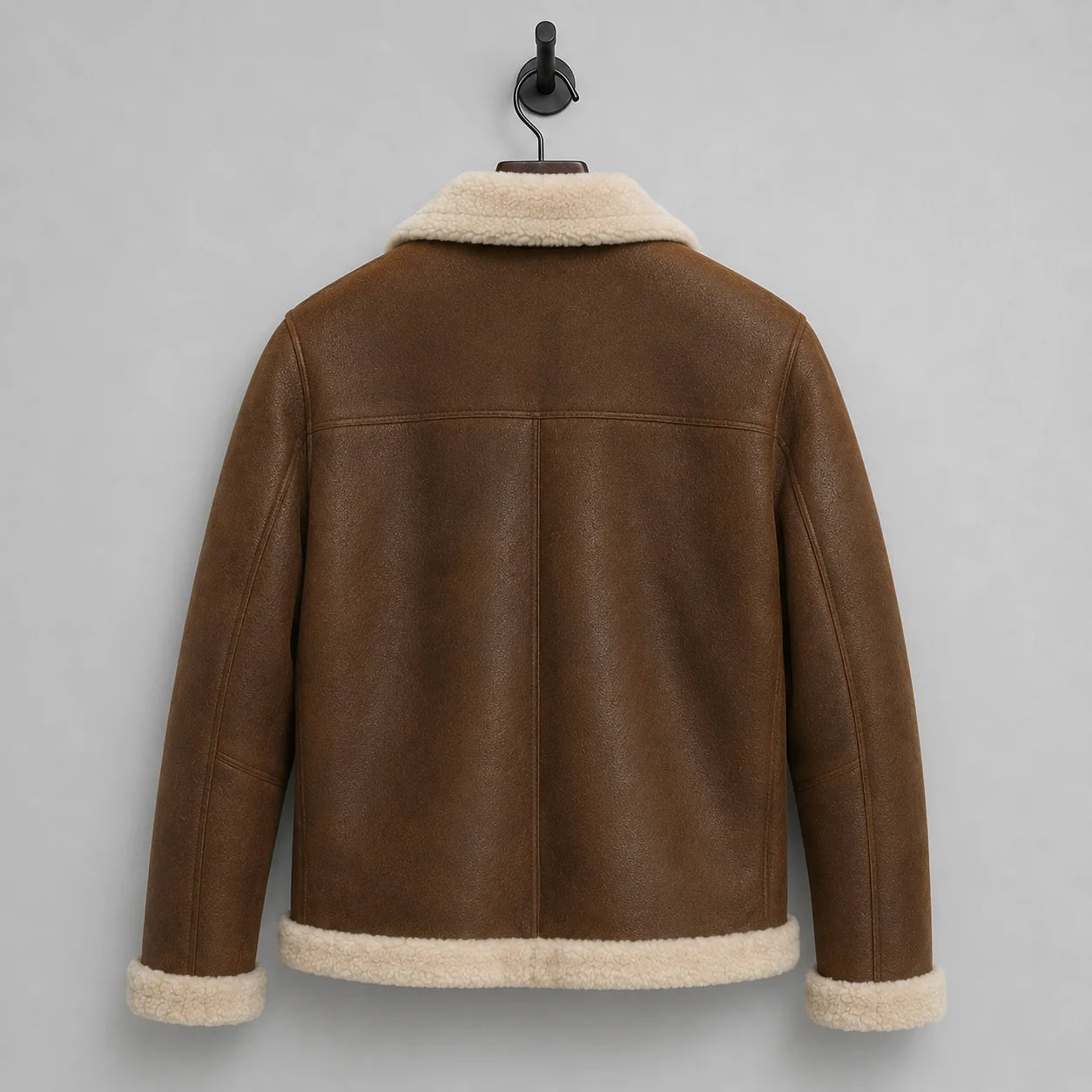 Hanging rear view of brown aviator jacket showing clean shoulder yoke, centre seam and off-white plush hem