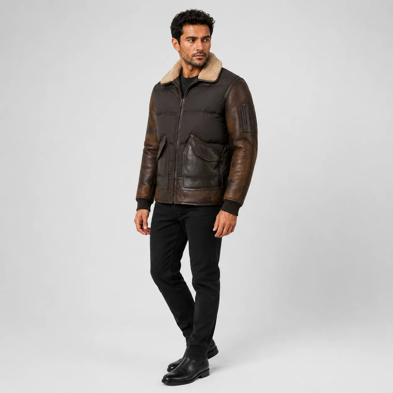 Three-quarter view of brown leather sleeve puffer bomber with flap pockets and upper-arm zip pocket.