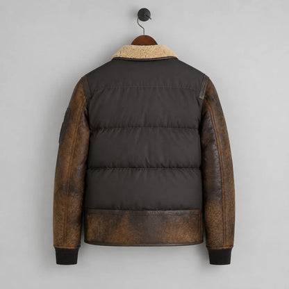 Hanging rear view showing quilted dark brown puffer body, distressed leather sleeves and leather lower panel.