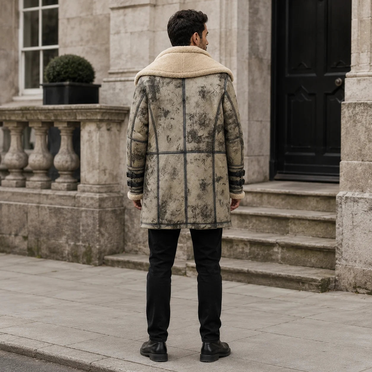 Rear outdoor view of long grey shearling aviator coat showing cream collar, dark piping and structured back panel seams