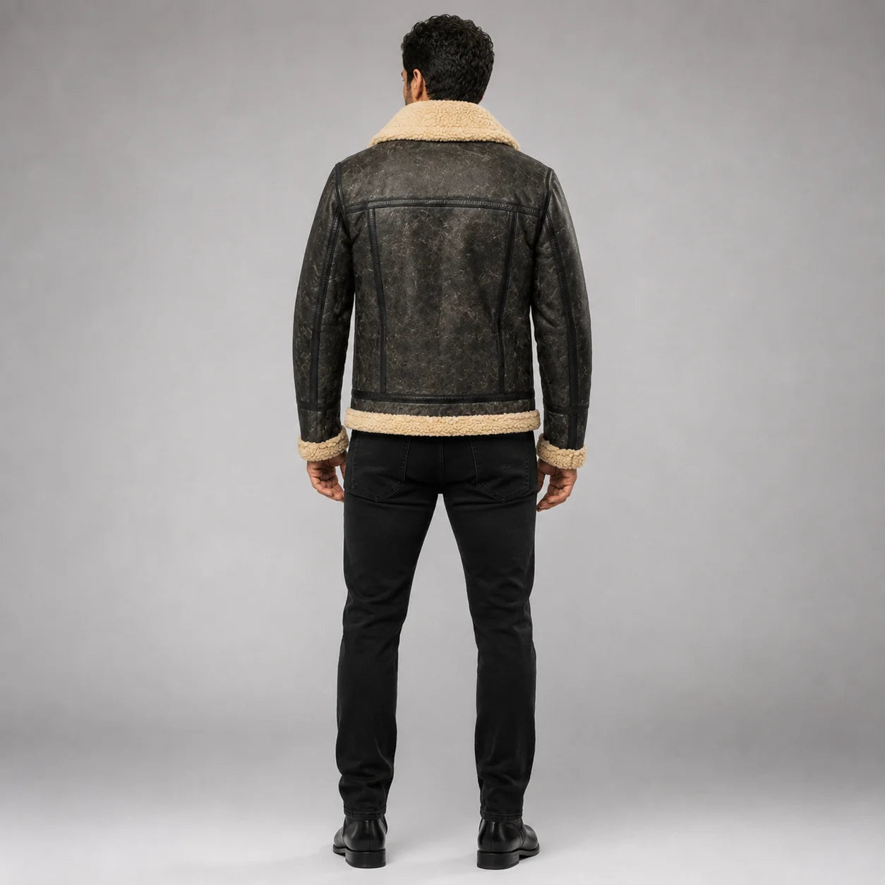Rear studio view of waxed sheepskin jacket showing cream Sherpa collar and hem with structured back panel seams